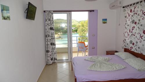 a bedroom with a bed and a balcony at Apartments Neri in Ksamil