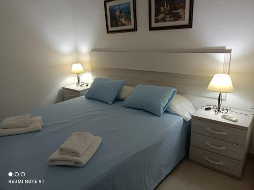 a bedroom with a large bed with blue pillows at Villa Celia in Son Bou