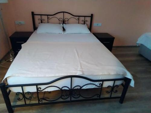 a bed with a black frame and a white mattress at Blue House in Mugla