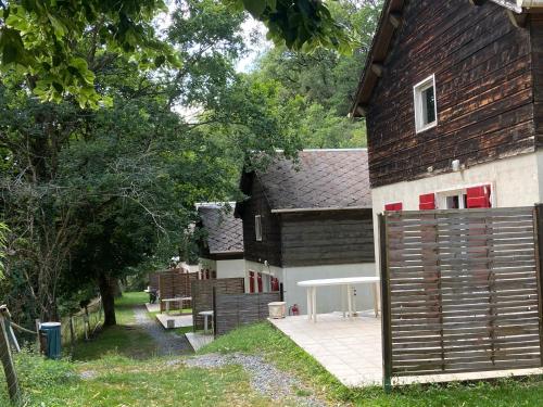 a barn with a wooden gate in front of a house at La Bastide d'Albignac in Le Dourn