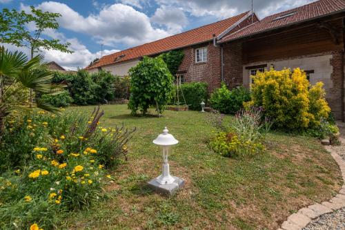 a garden with a birdbath in the yard of a house at Gîte Cosy Green in Chevincourt