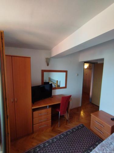 1 dormitorio con escritorio y silla roja en VILA MARKO, en Niška Banja