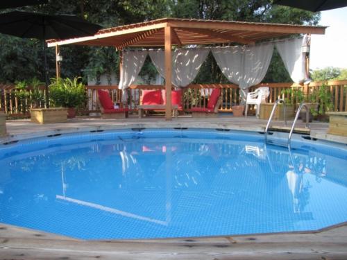 una gran piscina azul con cenador en אמיתי נוף קסום en Moshav Ramot