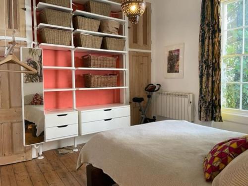 a bedroom with a closet with white drawers and a bed at Artistic spacious flat in central Brixton in London