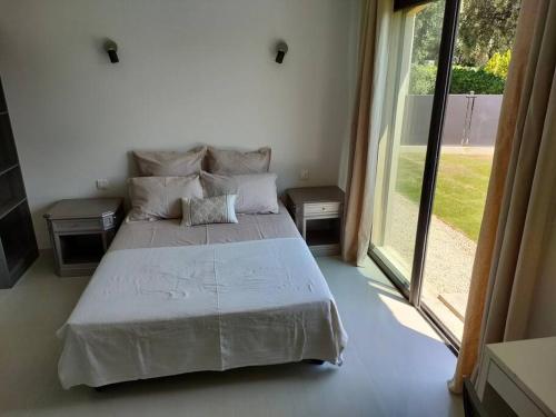 une chambre avec un grand lit et une grande fenêtre dans l'établissement MAGNIFIQUE VILLA MODERNE ENTRE MER ET MONTAGNE, à Le Tignet