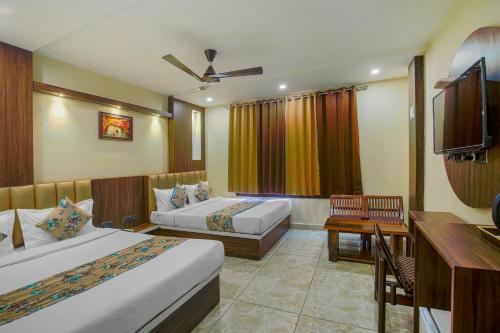 a hotel room with two beds and a desk at Hotel Crown, Amritsar in Amritsar