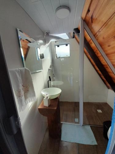 a small bathroom with a sink and a mirror at Chalé A-Frame da Fazenda in Bom Jardim da Serra