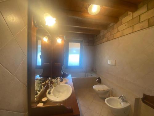 a bathroom with two sinks and a mirror and a tub at Villa Paola in Villa San Leonardo