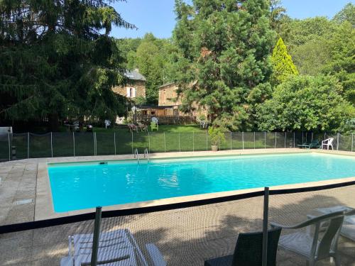 a swimming pool in a yard next to a house at La Bastide d'Albignac in Le Dourn