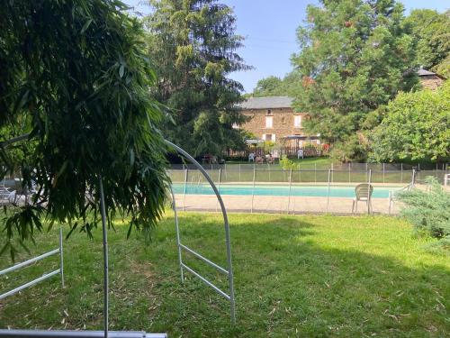 a swimming pool in a yard with a fence at La Bastide d'Albignac in Le Dourn