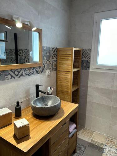 La salle de bains est pourvue d'un lavabo sur un comptoir en bois. dans l'établissement Location du Klan des K : villa 4 étoiles 150m plage, à Les Sables Vignier