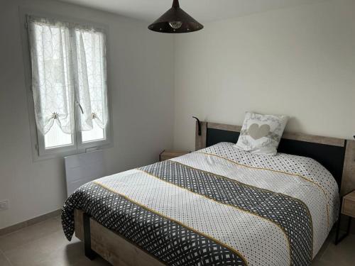 a bedroom with a bed with a pillow and two windows at Location du Klan des K : villa 4 étoiles 150m plage in Les Sables Vignier