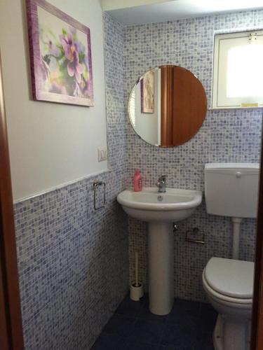 a bathroom with a sink and a toilet and a mirror at Casa vacanze Il Principe in Ravanusa