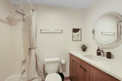 La salle de bains est pourvue de toilettes, d'un lavabo et d'un miroir. dans l'établissement Comfortable & Convenient Studio Apartment- Chestnut 23D, à Chicago