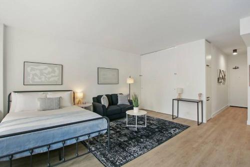 Comfortable & Convenient Studio Apt in Chicago - Chestnut 23D في شيكاغو: غرفة نوم كبيرة مع سرير وأريكة