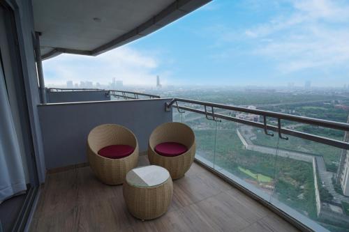 a balcony with two chairs and a view of a city at Hotel Livbox at Supernova in Noida