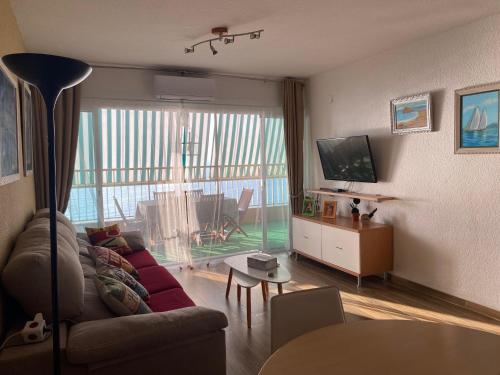 un soggiorno con un divano e una TV di Apt. New Holiday Valencia Beach a El Puig