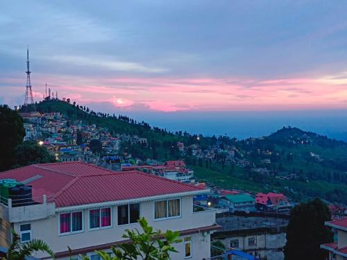 vista para uma cidade ao anoitecer com uma montanha em International Youth Hostel and Homestay Kurseong Bazar em Kurseong