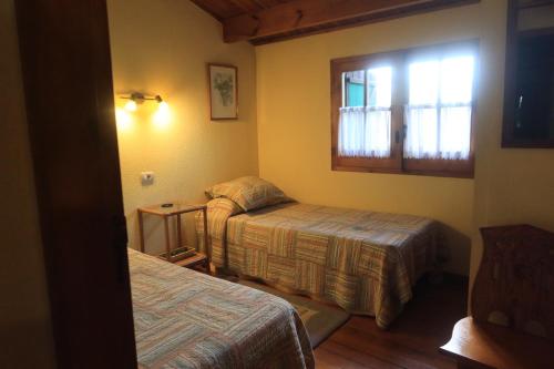 een hotelkamer met 2 bedden en een raam bij Shakti Rio Mino in San Bartolomé