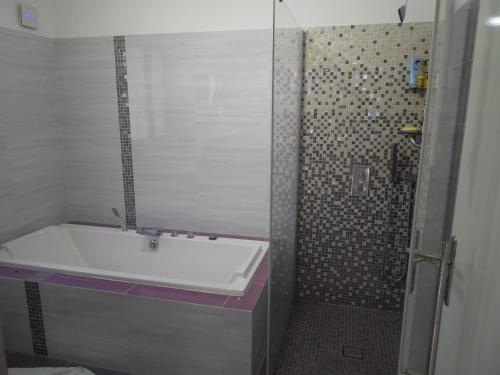 La salle de bains est pourvue d'une baignoire, d'une douche et d'un lavabo. dans l'établissement CHAMBRE PARENTALE 1, à Roquefort-les-Pins