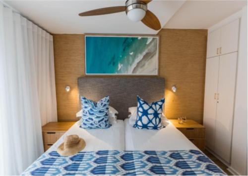 a bedroom with a bed with blue and white pillows at Luxury apartment in Gordons Bay in Gordonʼs Bay