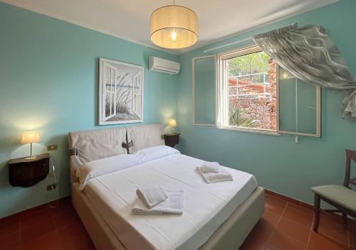 ein Schlafzimmer mit einem weißen Bett und einem Fenster in der Unterkunft Solemar Sicilia - Villa Elis in Bagheria