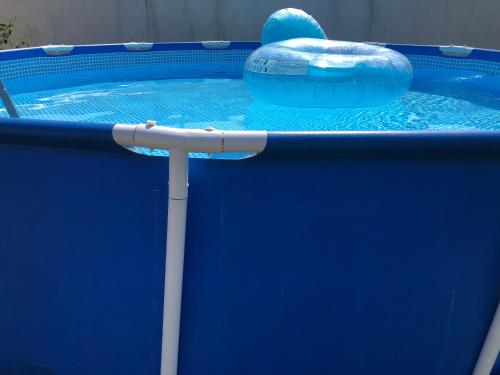 une piscine bleue avec un gonflable bleu dans l'établissement Les vieilles pierres drômoises, à Alixan