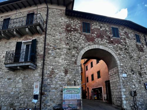 un accès à un bâtiment en pierre avec une arche dans l'établissement I Ninni, à Castiglione del Lago