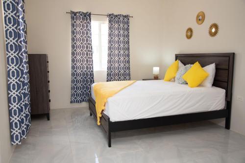 a bedroom with a bed with yellow and blue curtains at OceanView Villa in Discovery Bay