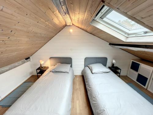 2 camas en una habitación pequeña con ventana en The Patio By Disney, 3 chambres, 2 salles de bain, en Lagny