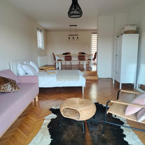 Sala de estar con 2 camas y mesa en Sienas Holiday Home en Vrnjačka Banja