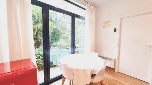 een witte tafel en stoelen in een kamer met een raam bij 7viridis in Dendermonde