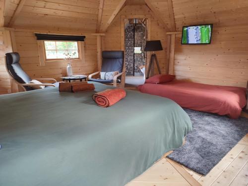 a bedroom with two beds and a tv in a cabin at Le kota des 3 tilleuls in Dampierre-sur-Salon