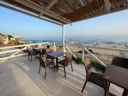 d'une terrasse avec des tables et des chaises sur la plage. dans l'établissement SPERLONGA VILLETTA SUL MARE CON ACCESSO ALLE SPIAGGIA POSIZIONE ESCLUSIVA, à Sperlonga