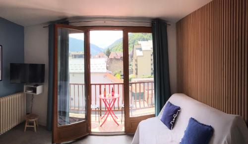 Habitación con cama y balcón con vistas. en Appartement 2 à 4 personnes Luchon centre, en Luchon