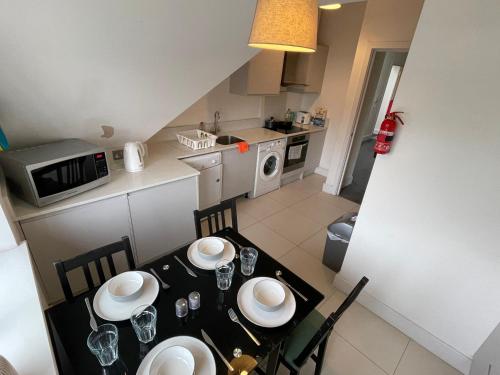 uma pequena cozinha com mesa e cadeiras num quarto em 2 Bedroom 2 bathroom Apartment 8 including free parking em Bromley