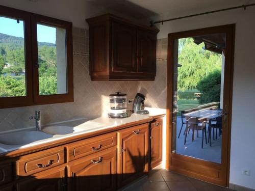 une cuisine avec un évier et une table avec des chaises dans l'établissement Gîte « Le Faucon pèlerin » Vue magnifique au calme, à Le Lautaret