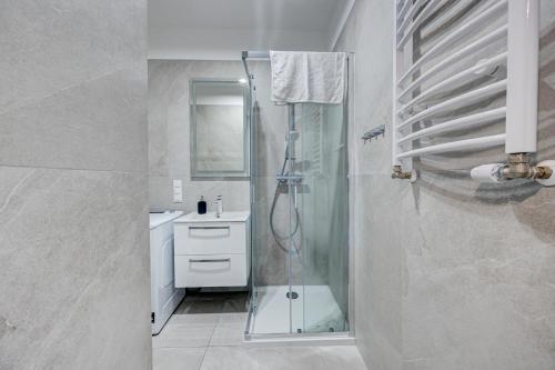 un bagno con doccia in vetro e lavandino di HANZA TOWER Swimming Pool & Spa 18 floor great view studio a Stettino