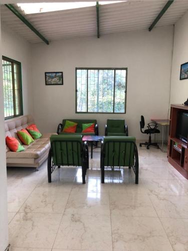a living room with green chairs and a couch at Hermosa Finca de descanso en Villa Samaria a 35 minutos de Melgar in Melgar