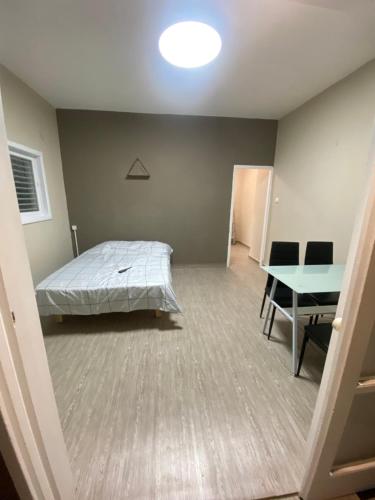 a bedroom with a bed and a table in it at Teper Apartment in Bat Yam