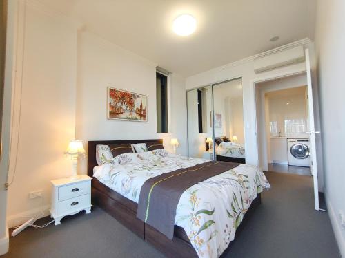 a bedroom with a large bed and a mirror at Comfy & Bright 1 Bed Apt Olympic in Sydney