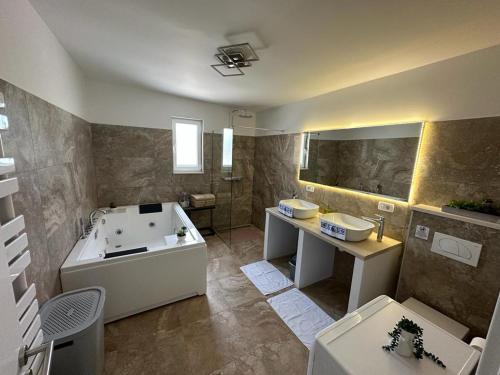 een grote badkamer met een bad en een wastafel bij Villa Green Hill, Cista Velika, Omis hinterland in Omiš