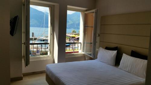 a bedroom with a bed with a view of the water at Hotel Danieli La Castellana lago di Garda in Brenzone sul Garda