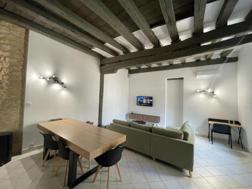 - un salon avec un canapé vert et une table dans l'établissement Atypique - Centre historique - Appartement 2 chambres, à Bourges