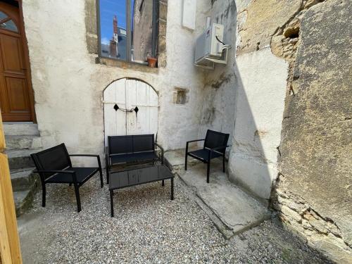 2 chaises et une table en face d'un bâtiment dans l'établissement Atypique - Centre historique - Appartement 2 chambres, à Bourges