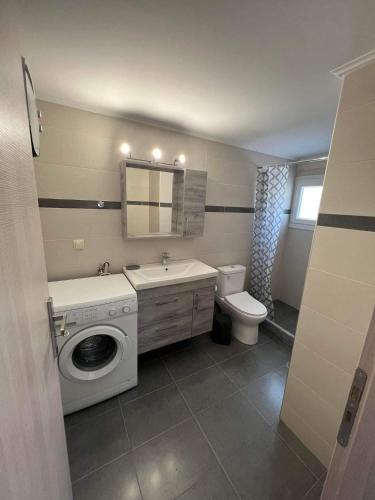 a bathroom with a washing machine and a sink at Karfas Seascape in Chios