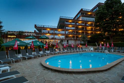 un hôtel avec une piscine, des chaises et un bâtiment dans l'établissement BSA Gradina Hotel - All Inclusive & Private Beach, aux Sables d'or