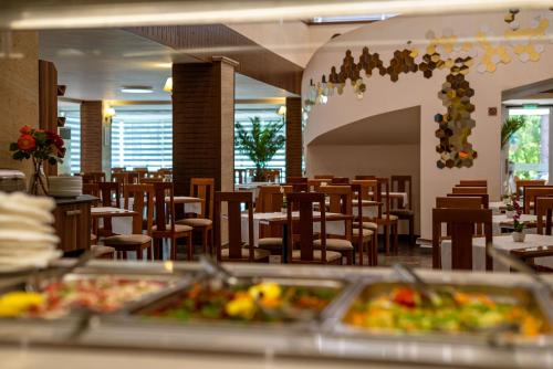 a dining room with tables and chairs and a cafeteria at BSA Gradina Hotel & Aquapark - All Inclusive in Golden Sands