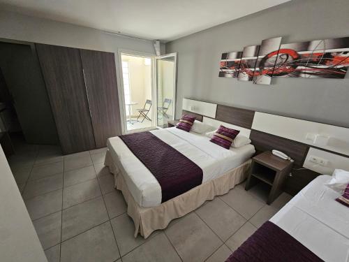 a hotel room with a large bed and a balcony at Holidays & Work HOTEL in Sanary-sur-Mer