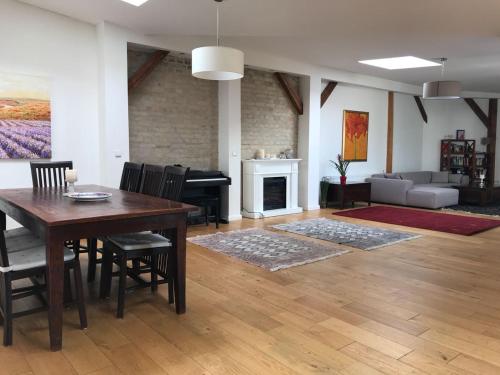 een woonkamer met een tafel en stoelen en een piano bij FBApartments in Berlijn